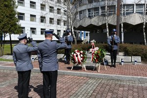 Zdjęcie kolorowe. Widoczni umundrowani policjanci przez Grobem Policjanta Polskiego na terenie KWP w Katowicach