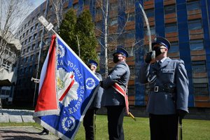 Zdjęcie kolorowe. Widoczni umundrowani policjanci - poczet sztandarowy ze sztandarem KWP w Katowicach