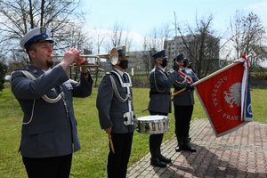 Zdjęcie kolorowe. Widoczni umundrowani policjanci - poczet sztandarowy ze sztandarem KWP w Katowicach oraz werblista i trębacz policyjny