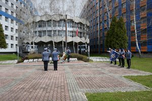 Zdjęcie kolorowe. Widoczni umundrowani policjanci przez Grobem Policjanta Polskiego na terenie KWP w Katowicach