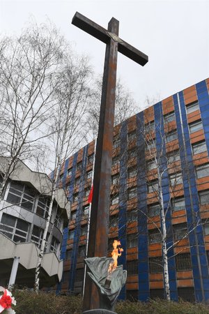 Zdjęcie kolorowe. Widoczny krzyż obok Grobu Policjanta Polskiego na terenie KWP w Katowicach