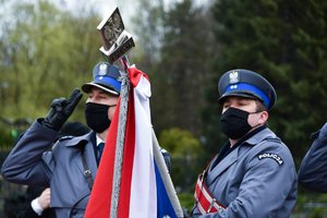 Poczet sztandarowy Komendy Wojewódzkiej Policji w Katowicach z opuszczonym sztandarem. Policjanci oddają honor.