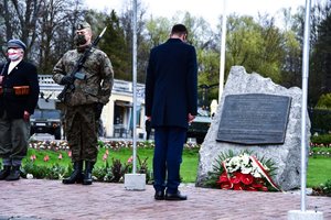 Premier składa kwiaty przed tablicą pamiątkową.