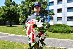 Policjant trzymający wieniec