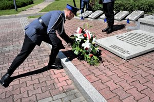 Policjant w umundurowaniu galowym składający wieniec na Grobie Policjanta Polskiego