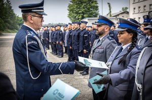 Komendant  Wojewódzki Policji w Katowicach inspektor Roman Rabsztyn wręcza akt mianowania i gratuluje funkcjonariuszce.