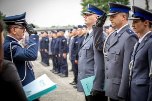 Komendant  Wojewódzki Policji w Katowicach inspektor Roman Rabsztyn wręcza akt mianowania i gratuluje funkcjonariuszowi.