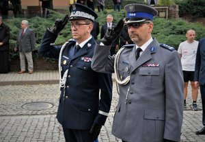 Kolorowa fotografia. Komendanci oddają honor poległym górnikom.