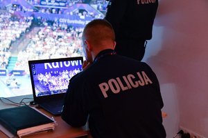 Policjant przed monitorem w policyjnym centrum dowodzenia.