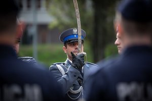 Zdjęcie kolorowe. Widoczi umundurowani policjanci podczas ślubowania