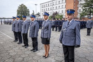 Zdjęcie kolorowe. Widoczi umundurowani policjanci podczas ślubowania