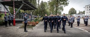 Zdjęcie kolorowe. Widoczi umundurowani policjanci podczas ślubowania