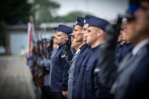 Zdjęcie kolorowe. Widoczi umunudorwani policjanci ślubujący