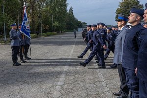 Zdjęcie kolorowe. Widoczi umunudorwani policjanci ślubujący