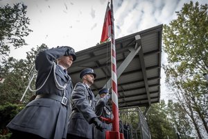 Zdjęcie kolorowe. Widoczy policyjny poczet flagowy podczas uroczystości