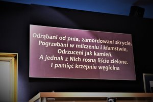 Napis na ścinie w Izbie Pamięci o następującej treści: odrąbani od pnia, zamordowani skrycie, pogrzebani w milczeniu i kłamstwie, odrzuceni jak kamień. A jednak z nich rosną liście zielone. I pamięć krzepnie węgielna.