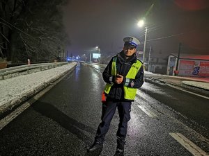 Policjant Wydziału Ruchu Drogowego podczas służby. w tle zimowa aura.