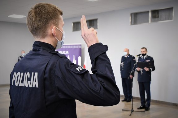 Umundurowany, nowo przyjęty policjant podczas ślubowania oraz Komendant Wojewódzki Policji w Katowicach.