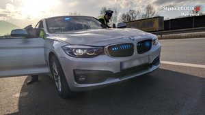 policjanci ruchu drogowego wysiadają z nieoznakowanego radiowozu marki BMW