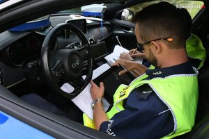 policjanci grupy speed w nieoznakowanym radiowozie sporządzają dokumentację służbową