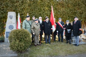 Widoczni uczestnicy uroczystości, mundurowi i cywile na terenie cmentarza