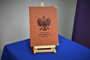 Zdjęcie kolorowe. Widoczni umundurowani policjanci biorący udział w uroczystym ślubowaniu nowych mundurowych.