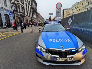 Zdjęcie kolorowe. Widoczne policyjne radiowozy i policjanci na terenie Katowic