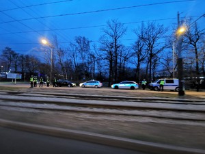 Zdjęcie kolorowe. Widoczne policyjne radiowozy i policjanci na terenie Katowic