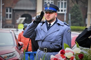 Umundurowany policjant oddaje honor.