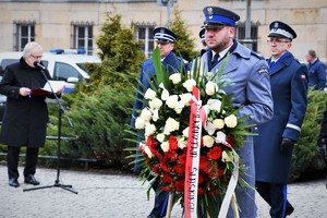 Delegacja służb mundurowych składa kwiaty.