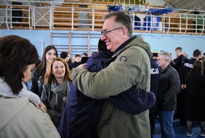 Mężczyzna przytula policjanta, który dopiero co złożył ślubowanie.