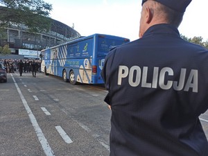 Widoczni umundurowani policjanci i radiowozy oraz kibice w drodze na mecz