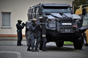 Na zdjęciu umundurowani policjanci i pojazd Tur