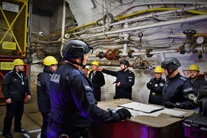 Na zdjęciu grupa policjantów oraz innych uczestników szkolenia w koalni obok windy
