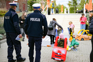 Zdjęcie. Widoczna grupa osób na placu, w tym umundurowani policjanci.