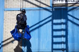 Policjant opuszczający się na linie z szybu kopalni