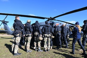 zdjęcie przedstawia policjantów zgrupowanych wokół śmigłowca