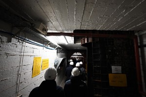 Zdjęcie przedstawia grupę osób w białych hełmach w korytarzach imitujących wnętrze kopalni