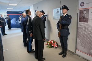 Zdjęcie. Widoczni umundurowani policjanci i uczestnicy uroczystości stojący w korytarzu