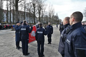 zdjęcie przedstawia czterech policjantów w trakcie ślubowania i poczet sztandarowy