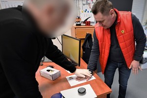 Zdjęcia. Gość oraz policyjny technik podczas daktyloskopii