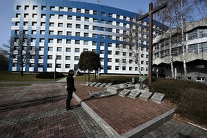zdjęcie przedstawia mężczyznę stojącego przed pomnikiem nieznanego policjanta