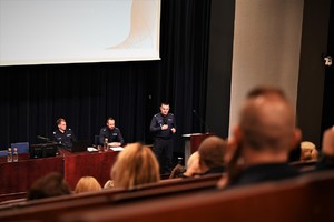 Zdjęcie. Widoczni uczestnicy konferencji, w tym umundurowani policjanci