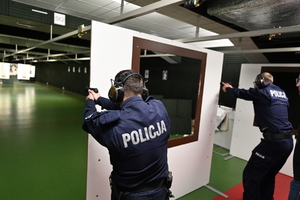 zdjęcie przedstawia policjantów w trakcie strzelania na strzelnicy