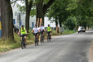 Zdjęcie. Widoczni uczestnicy wyprawy rowerowej w terenie