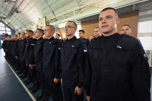 Zdjęcie. Widoczni stojący na sali sportowej umundurowani policjanci