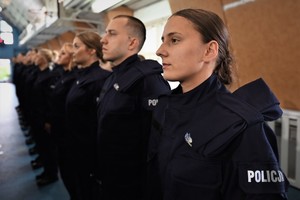 Zdjęcie. Widoczni stojący na sali sportowej umundurowani policjanci