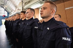 Zdjęcie. Widoczni stojący na sali sportowej umundurowani policjanci