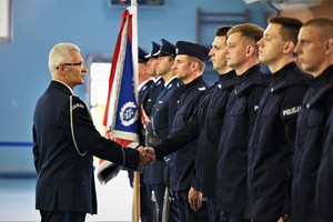 Zdjęcie. Widoczni stojący na sali sportowej umundurowani policjanci