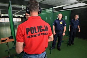 Zdjęcie. Widoczni umundurowani policjanci i instruktorzy na strzelnicy